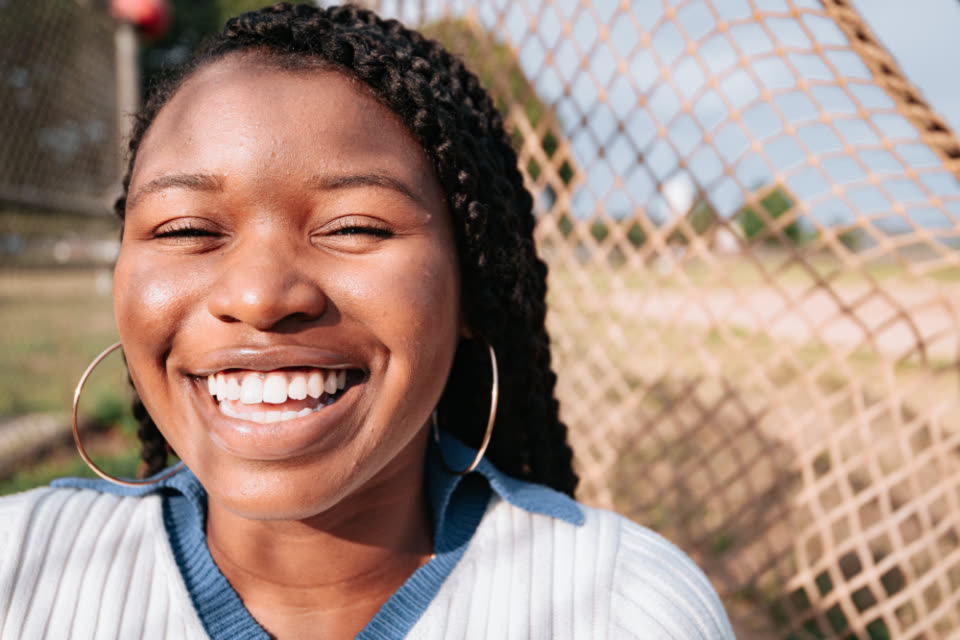 A woman laughing with a broad, natural smile